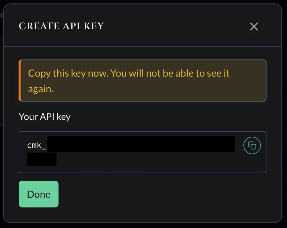 Create API key dialog showing the generated cmk_ key with a copy button and a warning that it won’t be shown again.